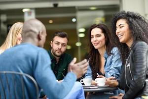 grupo multirracial de cinco amigos tomando un café juntos foto