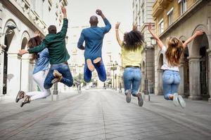 Group of friends jumping together outdoors photo