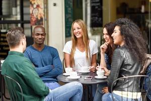 grupo multirracial de cinco amigos tomando un café juntos foto