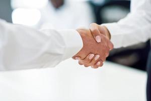 Caucasian businessman shaking hands with businesswoman in an office