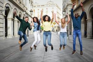 grupo de amigos saltando juntos al aire libre foto