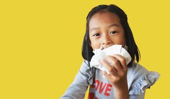 Asian girls eating food wrapped in food wrapping paper on yellow background.