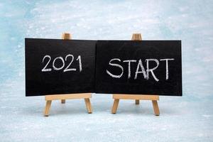 The message 2021 START is written in white chalk on a black chalk board. photo