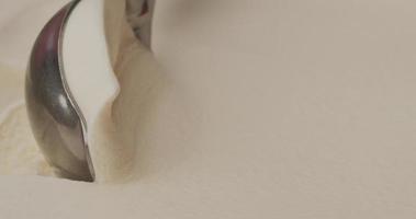 close-up, detalhes da textura do sorvete de baunilha após colher com a colher. video