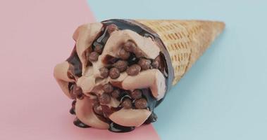 primo piano, sciogliendo il gelato al cioccolato su un cono di cialda. flusso di cioccolato. sullo sfondo bicolore video