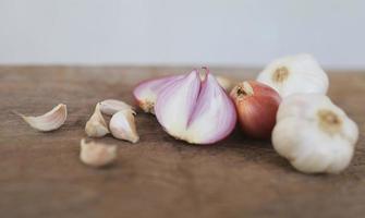 Cebolla y ajo para cocinar sobre fondo de madera vieja foto