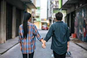 Two loving women standing and holding hands on the street. photo