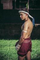 Thai boxers wrap the tape in the hands and stand on the lawn. photo