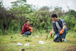 hombres y mujeres se ayudan mutuamente a recoger basura. foto