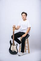 Girl sitting on a chair and holding a guitar. photo