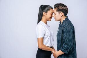 Women couples stand and fragrant cheek. photo