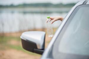 Holding a water bottle and sticking out the car. photo