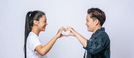Two young women love each other hand mark heart shape.