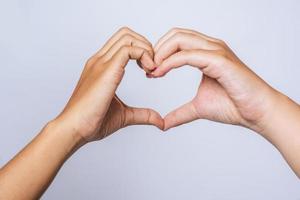 dos mujeres jóvenes se aman en forma de corazón de marca de mano. foto