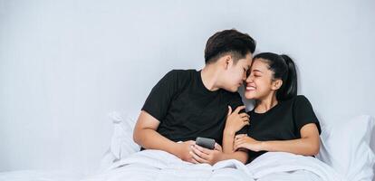 Two loving women sleeping and playing smartphones. photo