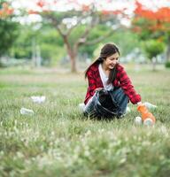 woman collecting garbage in a black bag. photo