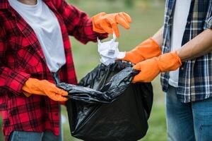 Men and women help each other to collect garbage. photo