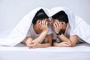 Two beloved young men slept in bed together. photo