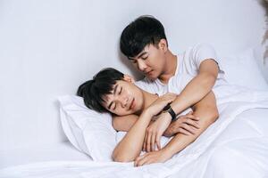 Two beloved young men slept in bed together. photo