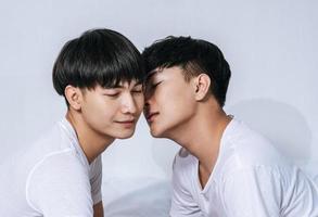 Two loving young men hugged and fragrant cheek each other. photo
