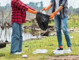 hombres y mujeres se ayudan mutuamente a recoger basura. foto