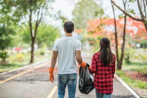 Men and women help each other to collect garbage. photo