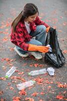 woman collecting garbage in a black bag. photo