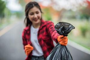 woman collecting garbage in a black bag. photo