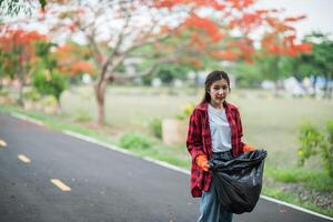 woman collecting garbage in a black bag. photo