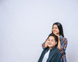 Two women in love stand and place their hands on each other's heads. photo