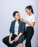 Two women lovers grab another shoulder and sit in a chair. photo