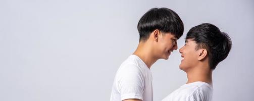 Two men in love wearing white t-shirts looked at each other's faces. photo