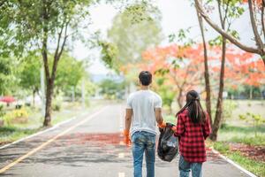 Men and women help each other to collect garbage. photo