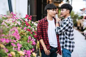 Two beloved young men in shirts and standing on the curb. photo