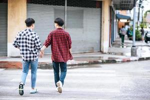 dos hombres que se aman se dan la mano y caminan juntos. foto
