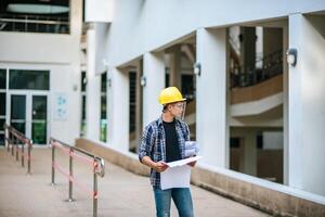 Architects hold the building plan and check the work. photo