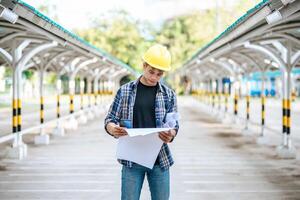 Architects hold the building plan and check the work. photo