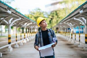 Architects hold the building plan and check the work. photo