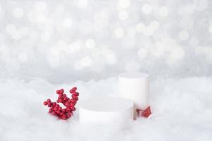 Maqueta de podio para cosméticos en la nieve con bayas decorativas sobre un fondo bokeh foto