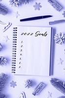 2022 goals in a spiral notepad on a desk with flat lay winter decor vertical format toned in very peri trendy color photo