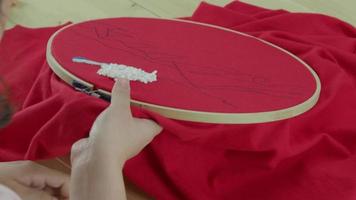 bordar cosiendo a mano de mujer. trabajo artesanal y manos femeninas. video