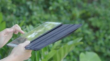 smartphone e giardino. utilizzando smartphone tablet nel cortile. video