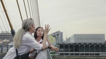 Frauen spielen Blasen auf einer Brücke. video