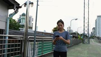 atletas femeninas que caminan usando teléfonos inteligentes escribiendo enviando mensajes. video