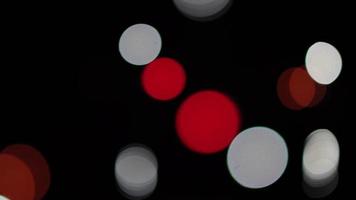 wazig donkere achtergrond met bokeh lichten in rood en wit in de verte. video