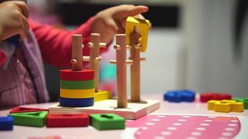uma criança brincando com brinquedos no jardim de infância. desenvolvimento criativo inicial com quebra-cabeças, artes e ofícios. conceito de imaginação, coordenação e pensamento artístico video