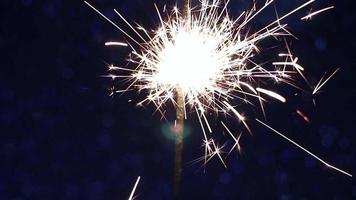 Bright sparkler on blue shiny background. video