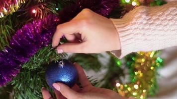 Woman removes decorations from Christmas tree.