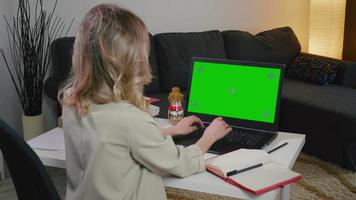 donna d'affari digitando sul computer con schermo verde in ufficio a casa. video