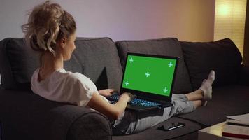 kvinna som arbetar hem tittar på grön skärm laptop. video